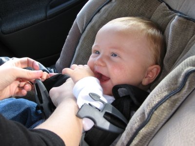 baby being buckled in carseat